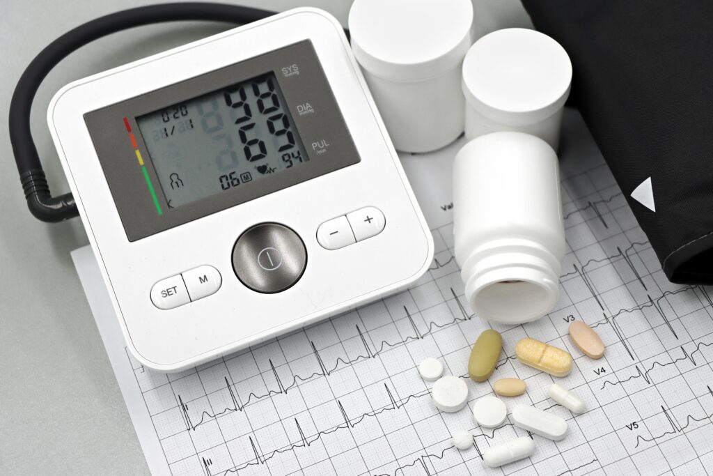 pexels photo 32210639 32210639 Blood pressure monitor with pills on ECG sheet, essential for heart health management.