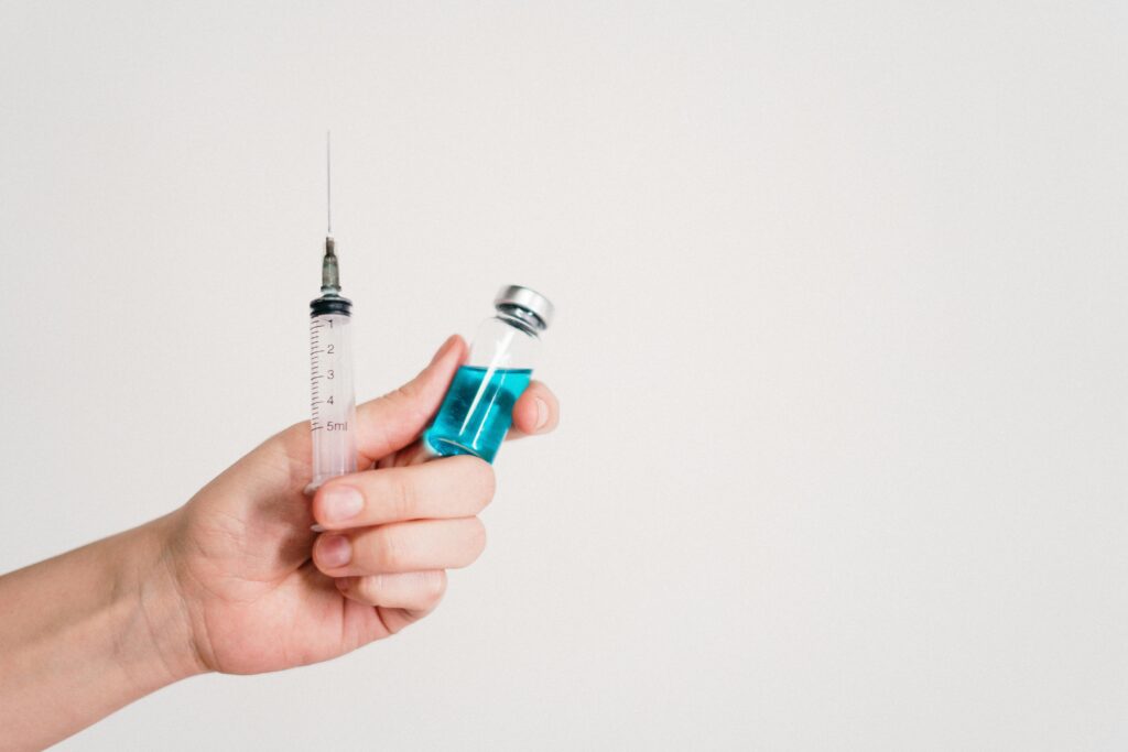 pexels photo 3952241 3952241 Hand holding a syringe and vaccine vial on a white background, symbolizing healthcare and immunization.
