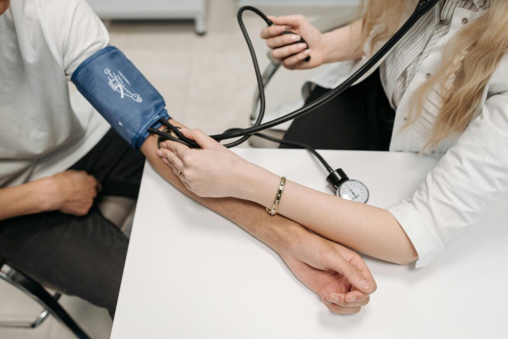 pexels photo 7108344 7108344 A doctor measures a patient's blood pressure with a sphygmomanometer during a consultation.